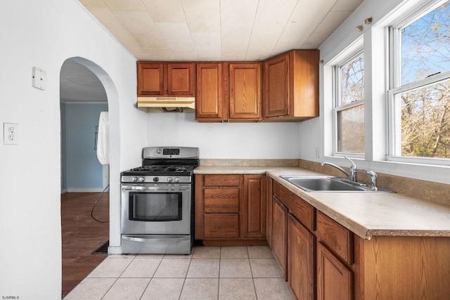 kitchen featuring sink, light tile patterned flooring, and gas range