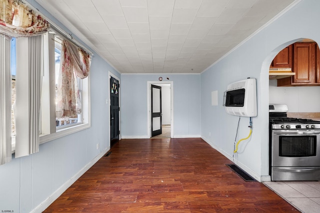 kitchen with ornamental molding, heating unit, gas stove, and dark hardwood / wood-style floors