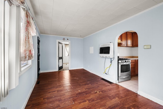 kitchen with heating unit, light hardwood / wood-style floors, crown molding, and stainless steel gas range oven