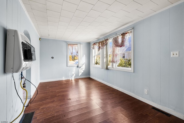 spare room featuring dark wood-type flooring and crown molding