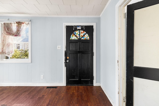 entrance foyer featuring ornamental molding and dark hardwood / wood-style flooring