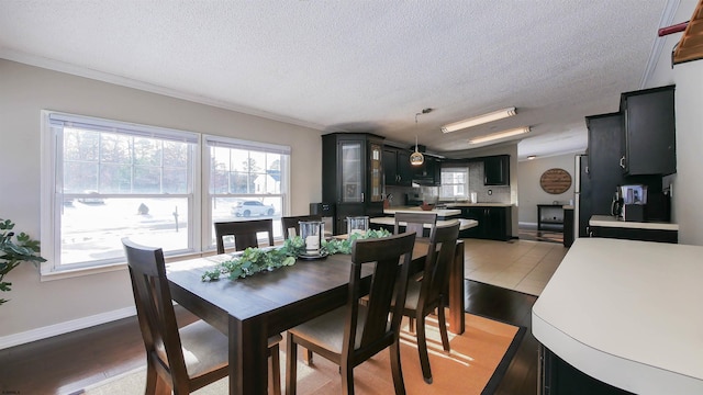 dining room featuring a textured ceiling, ornamental molding, and a wealth of natural light