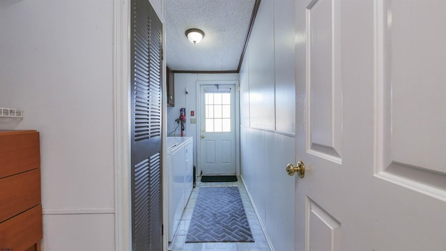 entryway with a textured ceiling and independent washer and dryer