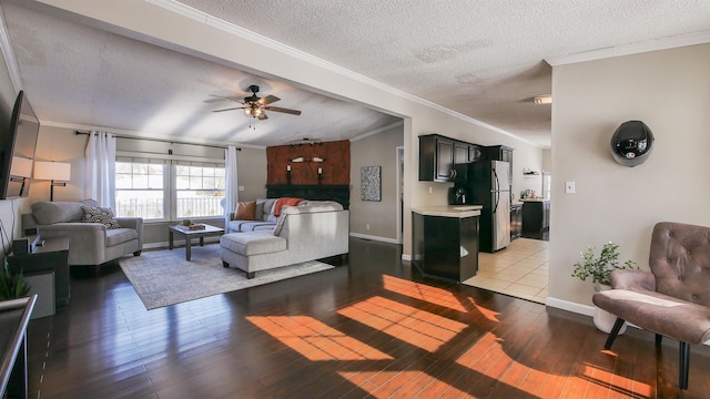 living room featuring light hardwood / wood-style floors, ceiling fan, ornamental molding, and a textured ceiling