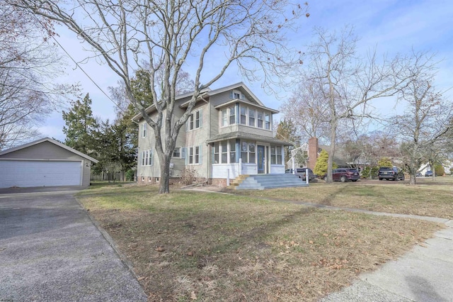 view of front facade featuring a garage, an outbuilding, and a front lawn