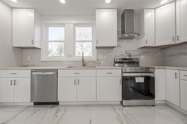 kitchen with stainless steel appliances, white cabinetry, sink, and wall chimney exhaust hood