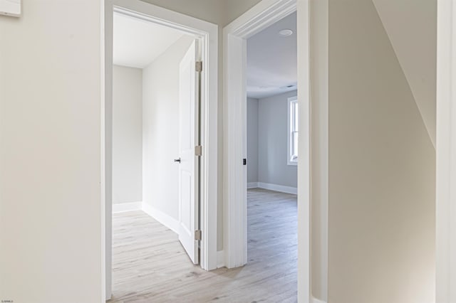 hallway with light hardwood / wood-style floors