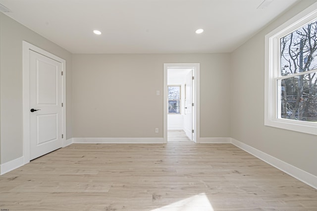 spare room featuring light hardwood / wood-style floors and plenty of natural light