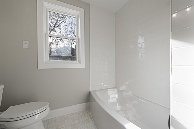 bathroom with bathing tub / shower combination, tile patterned floors, and toilet