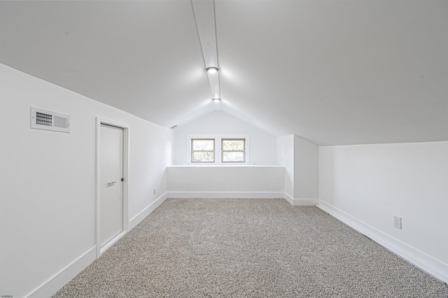 additional living space featuring carpet floors and vaulted ceiling