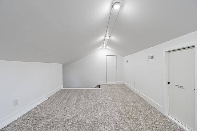 additional living space featuring lofted ceiling and light colored carpet