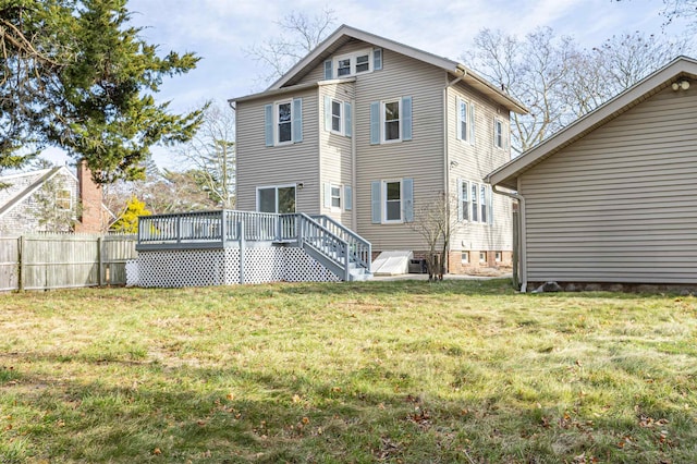 rear view of property with a yard and a deck