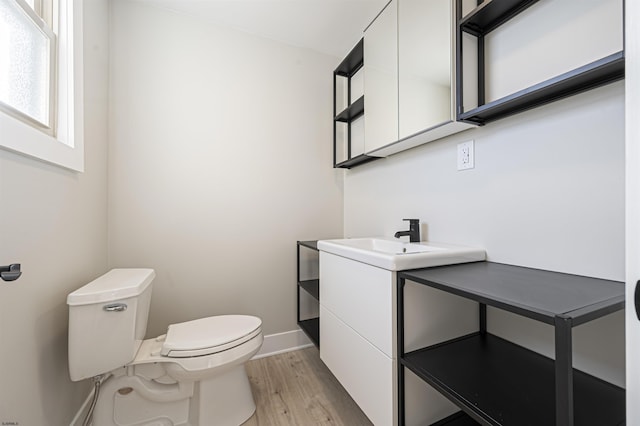 bathroom with toilet, vanity, and hardwood / wood-style floors