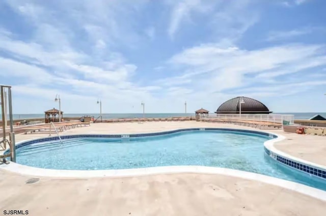 view of swimming pool featuring a water view