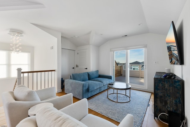 living room featuring lofted ceiling and light hardwood / wood-style flooring