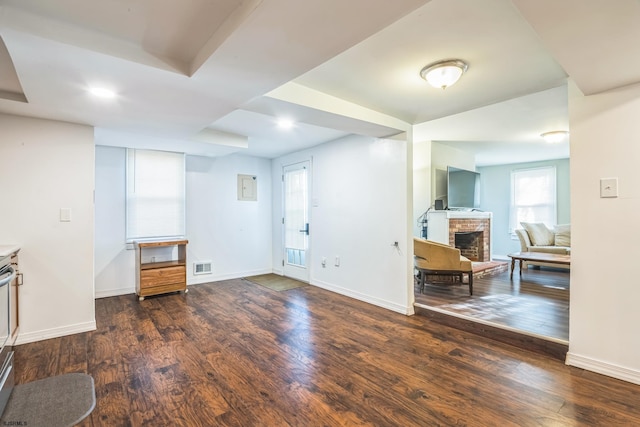 interior space featuring dark hardwood / wood-style flooring and a brick fireplace