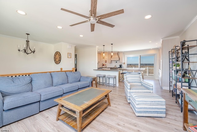 living room with light hardwood / wood-style floors, crown molding, and ceiling fan with notable chandelier