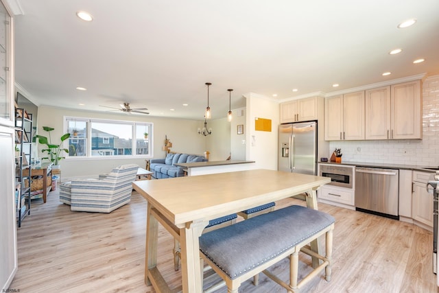 kitchen with ceiling fan, light wood-type flooring, tasteful backsplash, pendant lighting, and appliances with stainless steel finishes