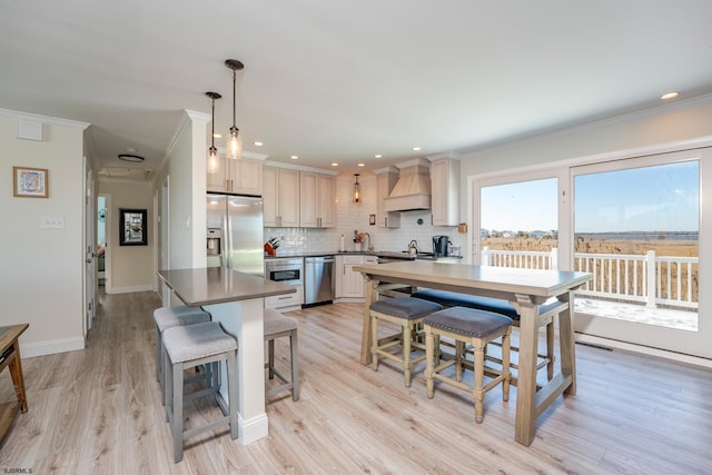 kitchen featuring custom exhaust hood, hanging light fixtures, stainless steel appliances, tasteful backsplash, and a kitchen breakfast bar