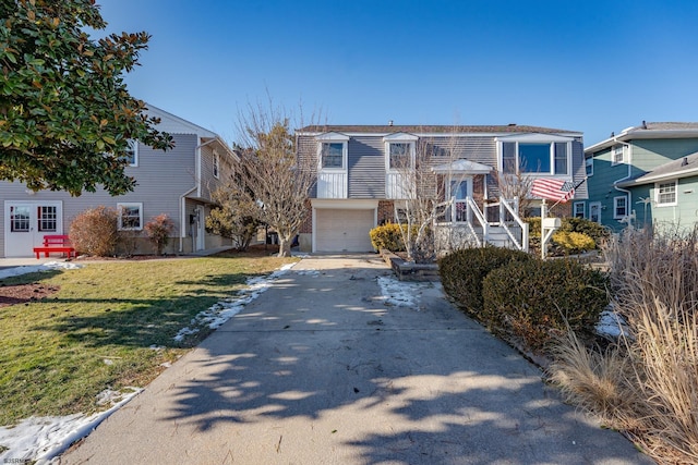 raised ranch with a garage and a front lawn