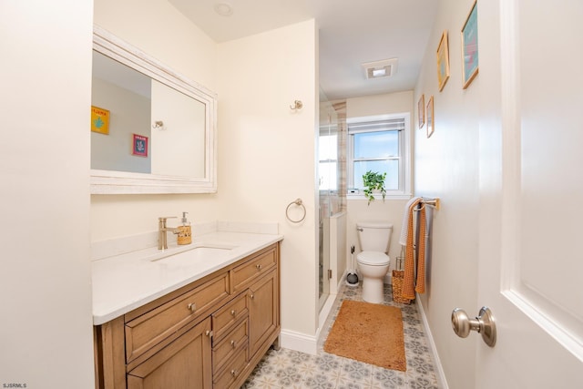 bathroom featuring toilet, an enclosed shower, and vanity