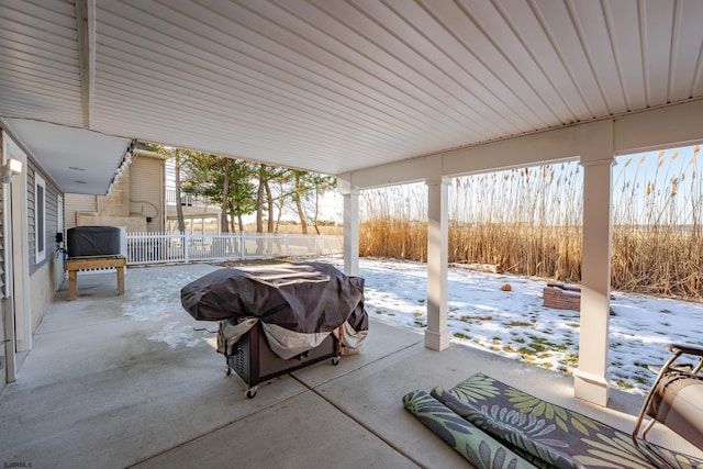 snow covered patio featuring a grill