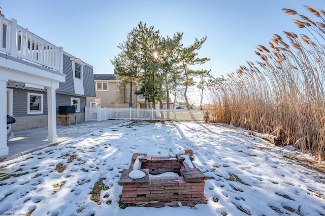 snowy yard featuring a balcony