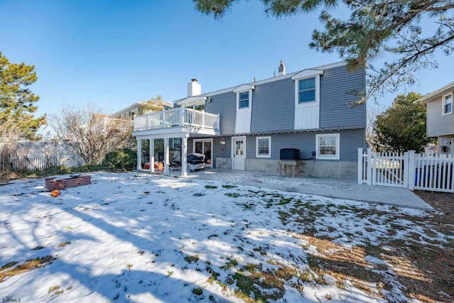 view of snow covered back of property