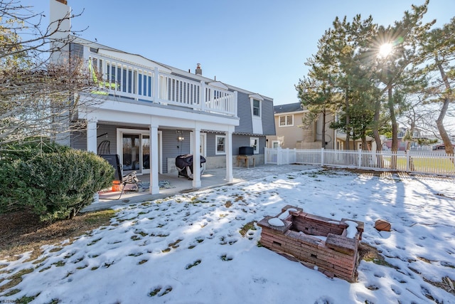 snow covered house featuring a balcony