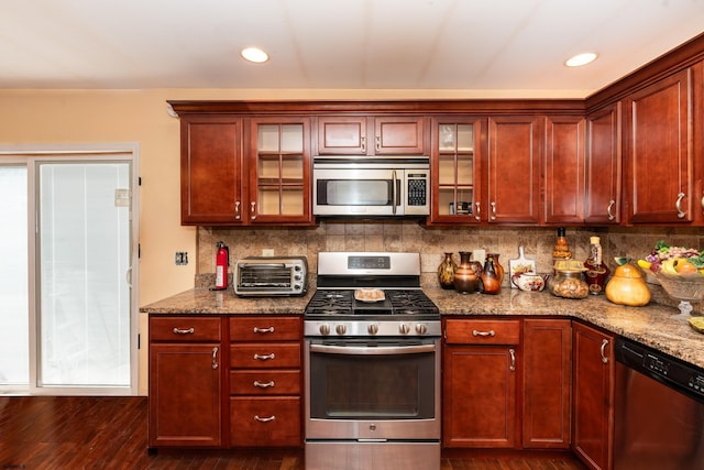 kitchen with stainless steel appliances, dark hardwood / wood-style flooring, tasteful backsplash, and light stone countertops