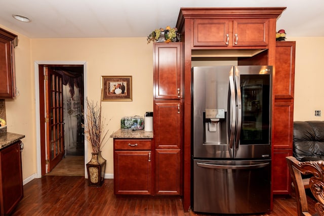 kitchen featuring stainless steel fridge, stone counters, and dark hardwood / wood-style floors