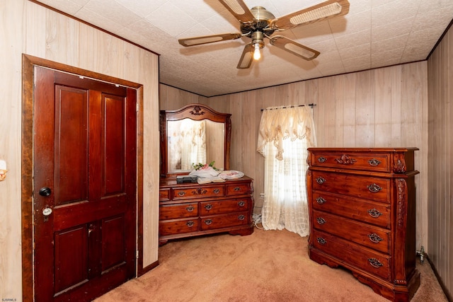 carpeted bedroom with ceiling fan and wooden walls