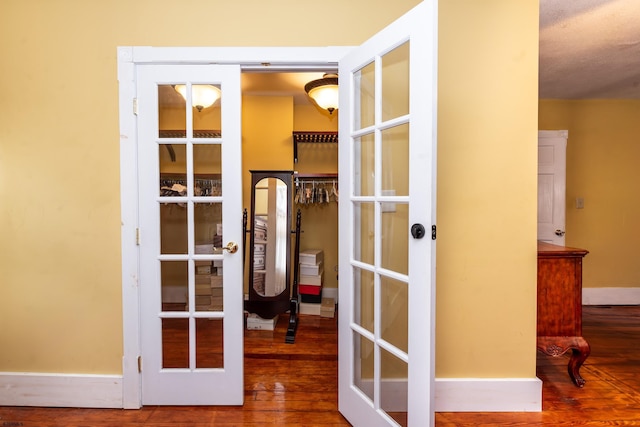 interior space with a textured ceiling, french doors, and hardwood / wood-style floors