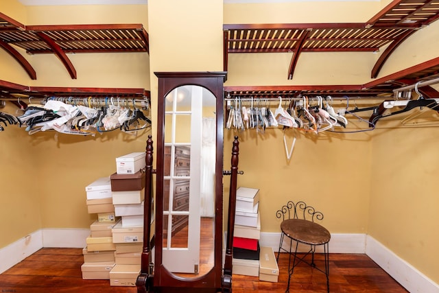 walk in closet with dark wood-type flooring