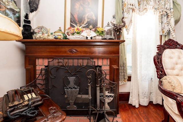 interior details featuring a brick fireplace and hardwood / wood-style flooring