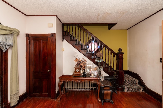 stairway with wood-type flooring, a textured ceiling, and ornamental molding