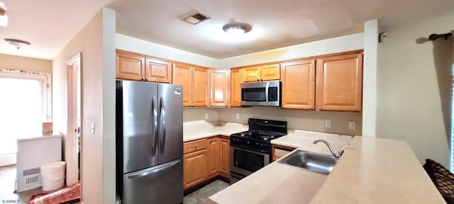 kitchen featuring appliances with stainless steel finishes, kitchen peninsula, and sink