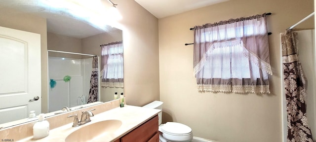 bathroom featuring a shower with shower curtain, vanity, and toilet