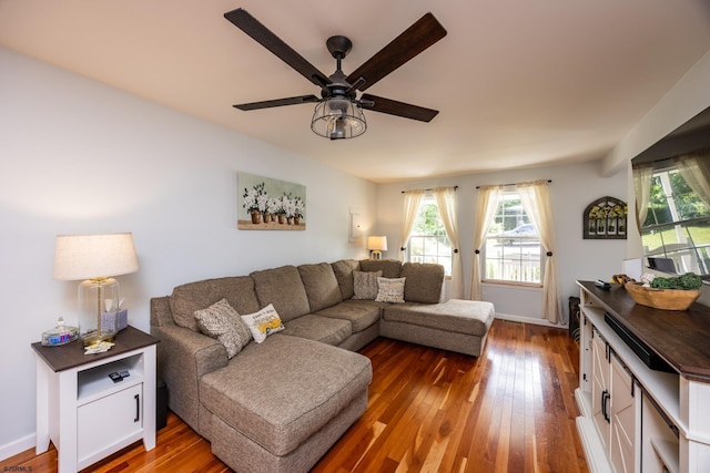 living room featuring ceiling fan and dark hardwood / wood-style floors