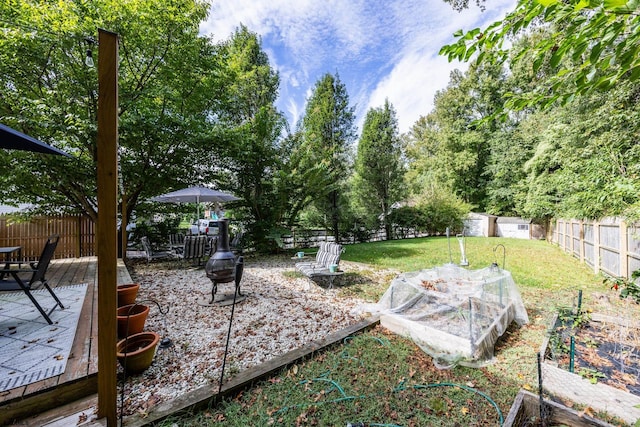 view of yard with a deck and a fire pit