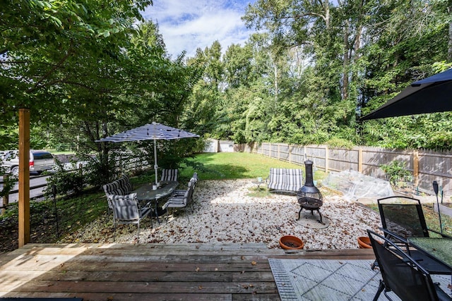 wooden deck featuring a fire pit and a yard