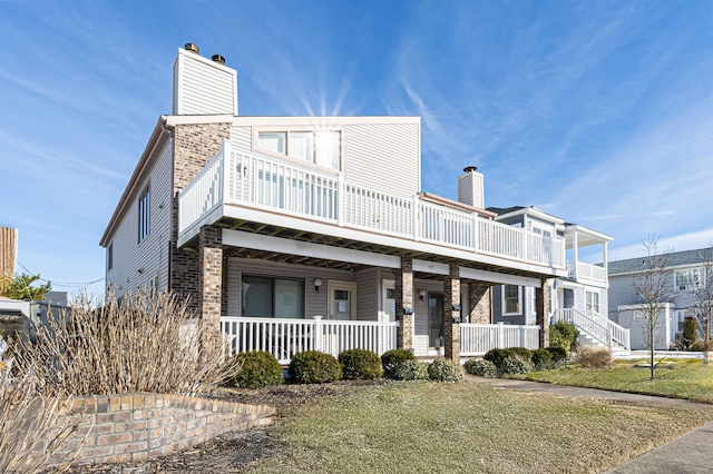 view of front of house featuring covered porch and a front lawn