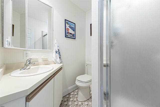 bathroom featuring toilet, an enclosed shower, and vanity