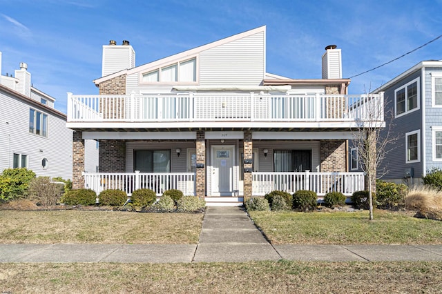 townhome / multi-family property featuring a porch and a front lawn