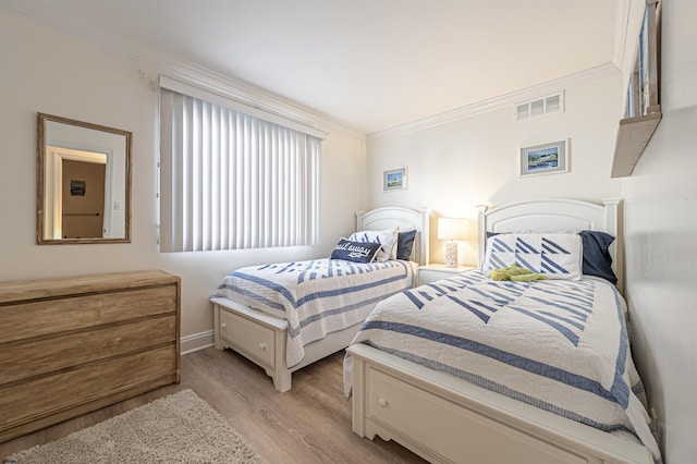 bedroom featuring light wood-type flooring and crown molding