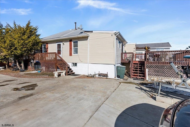 back of property featuring a deck and a patio area