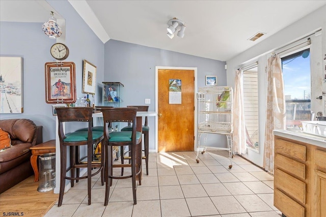 tiled dining area featuring lofted ceiling