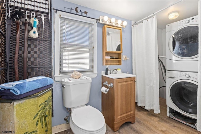 washroom with sink, stacked washer / drying machine, and light wood-type flooring