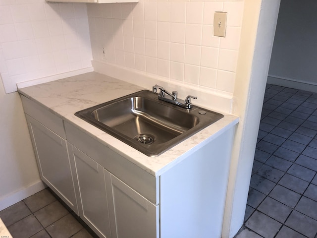 kitchen with gray cabinets, tile patterned floors, and sink