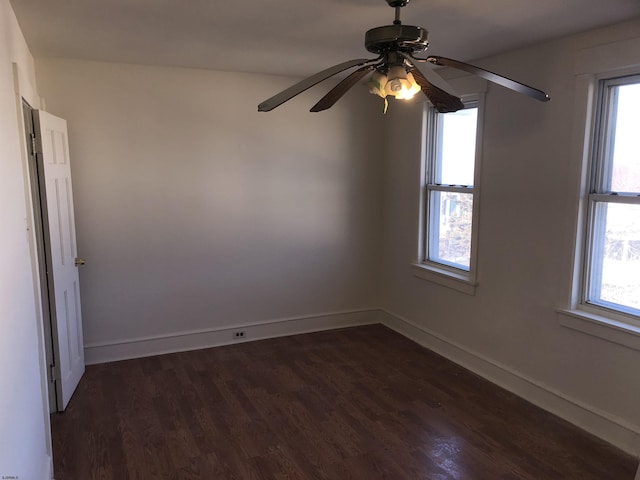 empty room with ceiling fan and dark hardwood / wood-style flooring